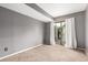 Bedroom with gray walls, tan carpet, and a sliding glass door at 401 S Kalispell Way # 104, Aurora, CO 80017