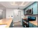 Bright kitchen featuring stainless steel appliances, wood countertops, and blue cabinetry at 401 S Kalispell Way # 104, Aurora, CO 80017