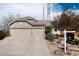 Lovely home exterior with stone accents, a 3-car garage, mature trees, and a landscaped front yard at 11302 Mesa Verde Pl, Parker, CO 80138