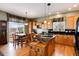 The kitchen is equipped with light wood cabinets, black appliances, an island with a marble top, and a breakfast table at 11302 Mesa Verde Pl, Parker, CO 80138