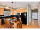 Updated kitchen featuring black appliances, stone counters, breakfast bar, and hardwood floors at 11302 Mesa Verde Pl, Parker, CO 80138