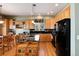 Well-appointed kitchen features wooden cabinetry, black appliances, granite counters, and an island with room for seating at 11302 Mesa Verde Pl, Parker, CO 80138