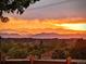 A stunning view of the colorful sunset behind layered mountain ranges from the property at 11302 Mesa Verde Pl, Parker, CO 80138