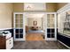 The office entrance features french doors that open into a living room with a picture window and a chandelier at 11302 Mesa Verde Pl, Parker, CO 80138