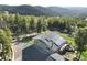 Beautiful aerial view showcasing a house with solar panels surrounded by lush greenery and trees at 8 Sioux Trl, Evergreen, CO 80439
