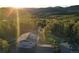 Stunning aerial view of a home nestled in the mountains with solar panels and mature trees at 8 Sioux Trl, Evergreen, CO 80439