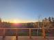 View of the sunrise from the wooden deck showcasing a view of the forest and the mountain range at 8 Sioux Trl, Evergreen, CO 80439