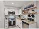 A beautifully renovated kitchen with stainless steel appliances, white cabinets and wooden shelving at 5300 E Cherry Creek South Drive # 918, Denver, CO 80246