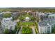 Aerial view of a park featuring a modern pavilion, walking paths, and lush landscaping, surrounded by urban buildings at 7700 E 29 Ave # 304, Denver, CO 80238