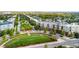 Aerial view showcases the park, modern residences, manicured landscape, and tree-lined streets in the residential area at 7700 E 29 Ave # 304, Denver, CO 80238