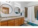 Well-lit bathroom featuring double sinks, wood cabinets, and a shower/tub combo at 7700 E 29 Ave # 304, Denver, CO 80238