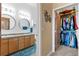 A well-lit bathroom featuring double sinks, wood cabinets, and a large closet at 7700 E 29 Ave # 304, Denver, CO 80238