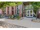The Lofts at Central Park: Entrance to 7700 building with brick facade, green landscaping, and sidewalk in front at 7700 E 29 Ave # 304, Denver, CO 80238