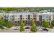 Exterior view of modern multi-story homes with brick accents, balconies, and lush landscaping, offering city living at 7700 E 29 Ave # 304, Denver, CO 80238