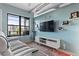 Comfortable living room with large window, exposed ductwork, hardwood floors, and modern furnishings at 7700 E 29 Ave # 304, Denver, CO 80238