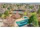 Aerial view showcasing tennis courts and a pool, near a neighborhood surrounded by lush trees at 11488 E Amherst S Cir, Aurora, CO 80014
