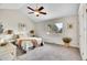 Bright bedroom features vaulted ceilings, a ceiling fan, plush carpet and a large window with neighborhood views at 11488 E Amherst S Cir, Aurora, CO 80014