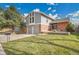 Charming two-story home with a well-manicured lawn, mature tree, and brick accents under a bright, cloudy sky at 11488 E Amherst S Cir, Aurora, CO 80014