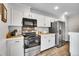 Well-equipped kitchen with white cabinetry, stainless steel appliances, and tile flooring at 11488 E Amherst S Cir, Aurora, CO 80014