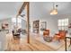 Spacious living room with a stone fireplace, hardwood floors, vaulted ceilings, and large windows at 11488 E Amherst S Cir, Aurora, CO 80014