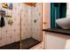 This bathroom features black and white tiling in the shower, gold fixtures and black countertop at 2240 S Clermont St, Denver, CO 80222