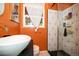 This bathroom features orange walls, a white vessel sink, and a glass enclosed shower at 2240 S Clermont St, Denver, CO 80222