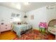 Bright bedroom with hardwood floors, a metal frame bed, colorful rug and pink nightstand at 2240 S Clermont St, Denver, CO 80222
