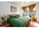 Sunny bedroom with large windows, gold curtains, hardwood floors, and a comfortable bed at 2240 S Clermont St, Denver, CO 80222