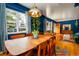Dining room leading into the living room, featuring a large window and wood furniture at 2240 S Clermont St, Denver, CO 80222