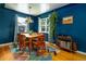Dining room with colorful rug, blue walls, hanging plant and vintage furniture at 2240 S Clermont St, Denver, CO 80222