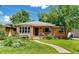 Charming brick home featuring a well-manicured lawn, front porch, and beautiful landscaping at 2240 S Clermont St, Denver, CO 80222