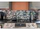 Kitchen stovetop with stainless steel appliances and mosaic tile backsplash at 2240 S Clermont St, Denver, CO 80222