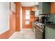 Charming kitchen featuring stainless steel appliances, warm orange walls, and light-filled window at 2240 S Clermont St, Denver, CO 80222