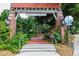 Denver Academy entrance showcasing brick columns, a decorative gate, and lush greenery at 2240 S Clermont St, Denver, CO 80222