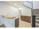 Finished basement with a wet bar, cabinets, tile flooring, and carpeted stairs at 3366 Willow St, Denver, CO 80238