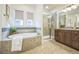 Bathroom featuring a soaking tub, tiled shower, and a wooden vanity at 3366 Willow St, Denver, CO 80238