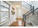 Welcoming entryway with hardwood floors, bright windows, and a staircase featuring sleek black railings at 3366 Willow St, Denver, CO 80238