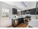 Updated kitchen with stainless steel appliances, white countertops and dark cabinetry, offering modern convenience at 6774 S Independence St, Littleton, CO 80128
