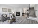 Bright living room features a cozy fireplace and an open floor plan leading to dining area at 6774 S Independence St, Littleton, CO 80128