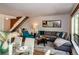 Cozy living room featuring hardwood floors, a large L-shaped couch, and view into the kitchen at 827 Maxwell Ave # H, Boulder, CO 80304