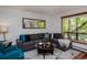 Comfortable living room with hardwood floors, neutral walls, large windows, and a gray L-shaped couch at 827 Maxwell Ave # H, Boulder, CO 80304