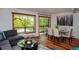 Bright living room featuring hardwood floors, neutral walls, and views of mature trees at 827 Maxwell Ave # H, Boulder, CO 80304