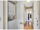 Hallway featuring a stacked washer and dryer, hardwood floors, and access to other rooms at 1099 S Walden Way # 205, Aurora, CO 80017