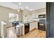 Functional kitchen and dining area with stainless appliances, hardwood floors, and vaulted ceilings at 1099 S Walden Way # 205, Aurora, CO 80017