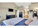 Bedroom with a comfortable bed, mounted TV, and adjoining bathroom at 1099 S Walden Way # 205, Aurora, CO 80017
