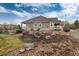 Landscaped backyard with rocks, and snow covered trees, bushes, and grass at 8101 S Quatar Cir, Aurora, CO 80016