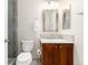 Well-lit bathroom featuring a wooden vanity and a glass door shower at 8101 S Quatar Cir, Aurora, CO 80016