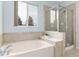 Bright bathroom features soaking tub and glass shower with tile surround at 8101 S Quatar Cir, Aurora, CO 80016