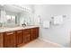 Bathroom features double vanity with wooden cabinets and large mirror at 8101 S Quatar Cir, Aurora, CO 80016