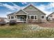Back of the house with siding and a snow covered lawn with trees at 8101 S Quatar Cir, Aurora, CO 80016